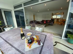 a table with a plate of food and a bottle of wine at Oxley's Waterfront Apartment in Picton