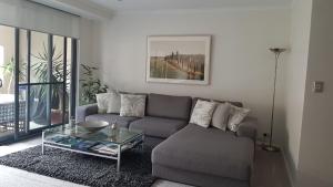 - un salon avec un canapé et une table en verre dans l'établissement West End District Apartments, à Fremantle