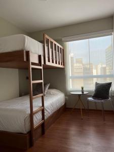 een slaapkamer met 2 stapelbedden en een raam bij MLA apartments - Alcanfores in Lima
