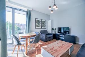 a living room with a table and chairs and a couch at CITYSTAY Garden Gates Apartment in Gdańsk