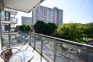a balcony with a table and chairs on a building at CITYSTAY Garden Gates Apartment in Gdańsk