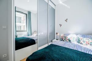 a bedroom with two beds and a large mirror at CITYSTAY Garden Gates Apartment in Gdańsk