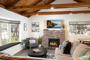 sala de estar con chimenea de ladrillo en Bayview Bungalow - Cabin with Hot Tub One Block from Big Bear Lake! en Big Bear Lake