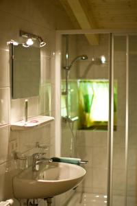 a white bathroom with a sink and a shower at Haus Sonnberg in Kals am Großglockner