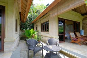 une terrasse avec des chaises et des tables dans une maison dans l'établissement Sunrise Villa Ubud, à Ubud