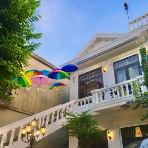 a group of colorful umbrellas hanging from a house at The Cau Garden House in Ấp Long Hồ Hạ