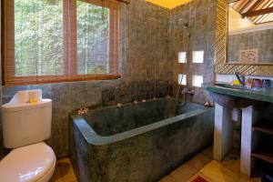 La salle de bains est pourvue d'une baignoire, de toilettes et d'un lavabo. dans l'établissement Sunrise Villa Ubud, à Ubud