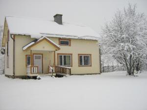 una pequeña casa cubierta de nieve con un patio en Farmhouse Tervamäki, en Tervajärvi