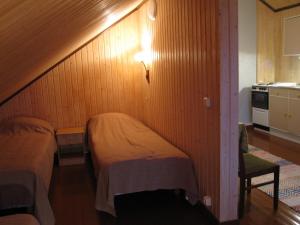Una pequeña habitación con dos camas y una cocina. en Farmhouse Tervamäki, en Tervajärvi 6 fotos más