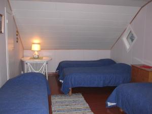 a room with two beds and a table with a lamp at Farmhouse Tervamäki in Tervajärvi