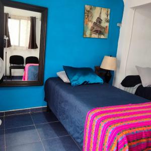 een blauwe slaapkamer met een bed en een spiegel bij Casa LUNA in Misiones de La Paz +8 foto's