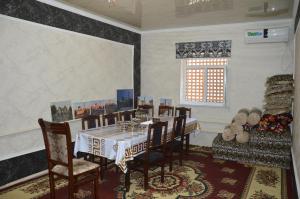 a dining room with a table and chairs and a window at Khiva Mirza Bobur Guest House in Khiva