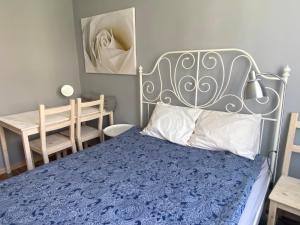 1 dormitorio con cama azul y cabecero de metal en Apartament Jana, en Tarnowskie Góry