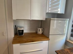 cocina pequeña con armarios blancos y nevera blanca en Apartament Jana, en Tarnowskie Góry