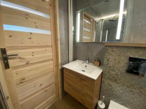 a bathroom with a sink and a wooden door at Apartament Jana in Tarnowskie Góry