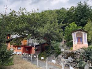 una casa en una colina con un árbol en LA CASA DEI NONNI con SPA privata su richiesta en Pont Canavese