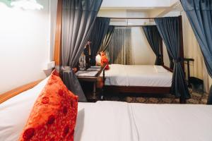 um quarto de hotel com duas camas e uma janela em Sleeper House em Trang