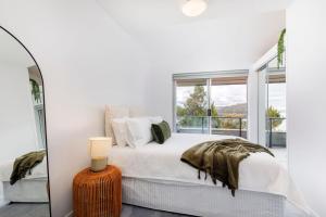 a bedroom with a bed and a large window at Kooringa 4 in Jindabyne