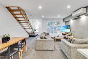 a living room with two couches and a table at Sherbourne Retreat in Newtown in Geelong