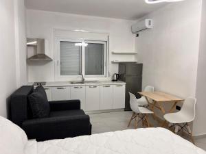 a bedroom with a bed and a chair and a table at Sunset Luxury Studios in Radhimë