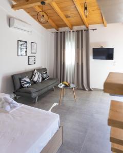 a living room with a bed and a couch at Spitakia-Cozy & Comfy Apartments 10minutes from the airport in Artemida