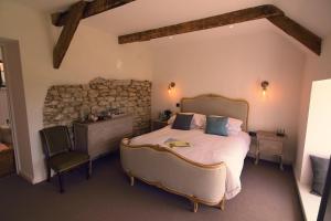 a bedroom with a bed and a stone wall at Luxurious property set in the heart of Cornwall with breathtaking views -Rhubarb Cottage in Helston