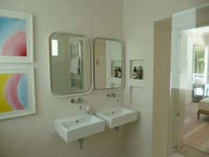 a bathroom with two sinks and a mirror at Villa Mimi Beachfront Beau Vallon in Beau Vallon