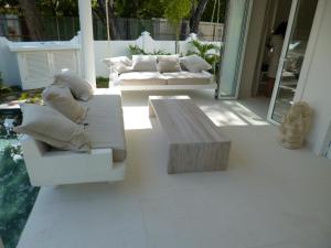 a patio with two couches and a coffee table at Villa Mimi Beachfront Beau Vallon in Beau Vallon