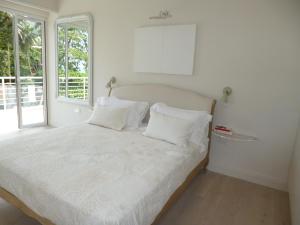 Schlafzimmer mit einem Bett mit weißer Bettwäsche und einem Fenster in der Unterkunft Villa Mimi in Beau Vallon