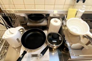 a kitchen counter with a frying pan and other kitchen utensils at ラ・ポート空港前101 in Shime