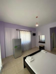 a living room with a bed and a refrigerator at Villa Sopebra in Sarandë