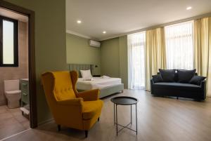 1 dormitorio con 1 cama, 1 sofá y 1 silla en Buxus Hotel Shekvetili en Shekhvetili