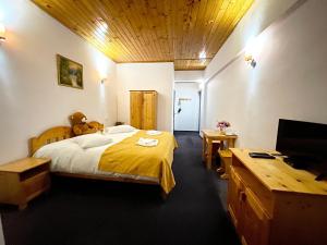 a bedroom with a bed with a teddy bear on it at Pensiunea Ursuleț Bran in Bran