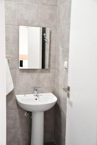 a bathroom with a white sink and a mirror at Heliofos Apartments in Stomio +21 photos