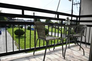 a table and chairs on a balcony with a view of a yard at Heliofos Apartments in Stomio