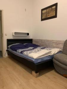 1 dormitorio con 1 cama, 1 silla y TV en Pension Lotti Friedrichshain en Berlín