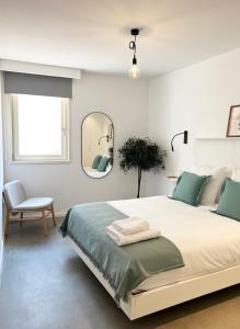 a bedroom with a bed with a mirror and a chair at HomeSanGil in Burgos