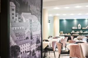 a restaurant with tables and chairs and a picture of a building at Roma Domus Hotel in Ponzano Romano