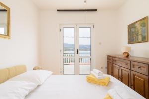 - une chambre blanche avec un lit et une fenêtre dans l'établissement Kuća za odmor Tommy, à Trogir