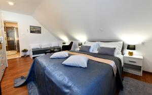 a bedroom with a large bed with two pillows on it at Rooms & Apartment Milan Saborsko in Saborsko