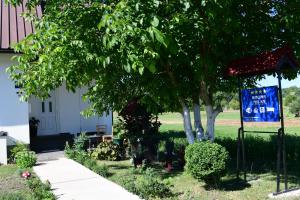 a sign in front of a house with a tree at Rooms & Apartment Milan Saborsko in Saborsko +62 photos