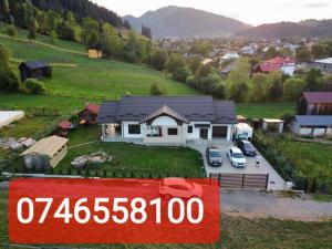 una casa con un cartel de precio delante en Casa Mia, en Câmpulung Moldovenesc