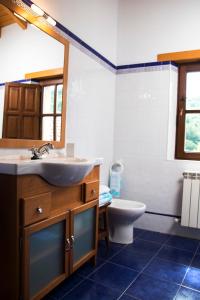 a bathroom with a sink and a toilet and a mirror at Casa Canela in Colladas