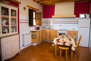 a kitchen with a table and a white refrigerator at Casa Canela in Colladas