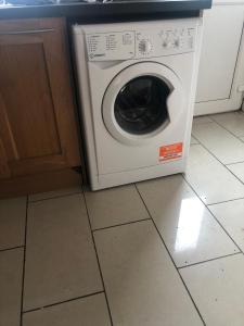 a washer and dryer sitting on the floor in a kitchen at Cheerful 4 bedroom town house with bbq, in Galway