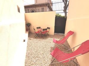 un patio con sillas rojas y una mesa en Coquet 2 pièces entièrement rénové et climatisé, en Cannes