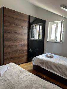 sypialnia z dwoma łóżkami i drewnianą ścianą w obiekcie Florena Novalja w Novalji