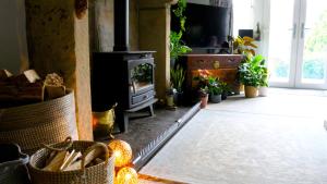 a living room with a fireplace and a stove at Romany Cottage B&B in Buckden