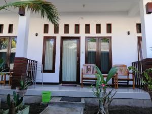 a front porch of a house with chairs and plants at Vacation Inn Gili in Gili Trawangan