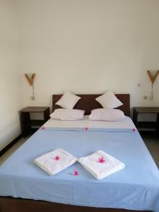 a bedroom with a blue bed with two towels on it at Vacation Inn Gili in Gili Trawangan